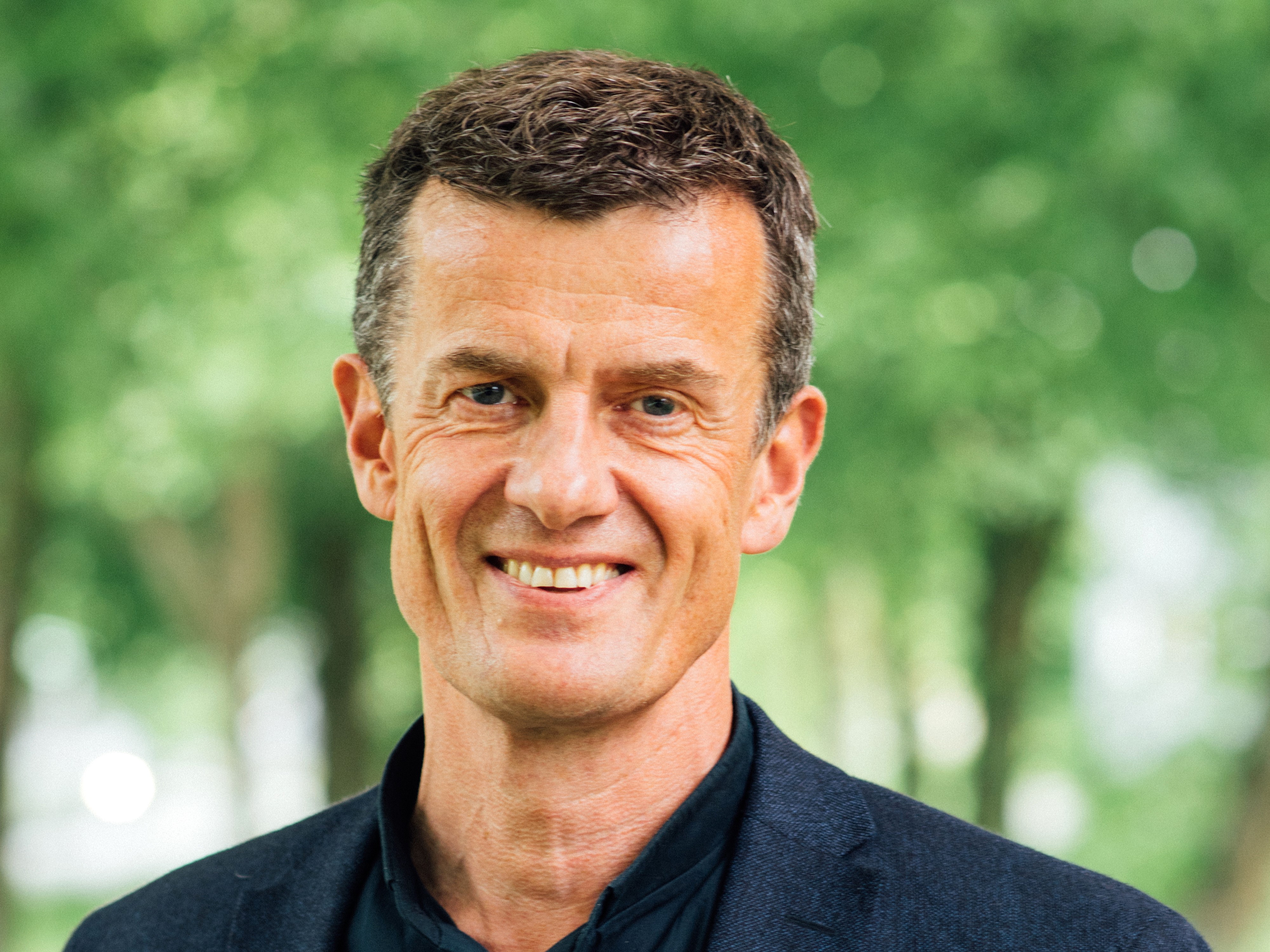 UiS rektor Klaus Mohn foran grønn bakgrunn