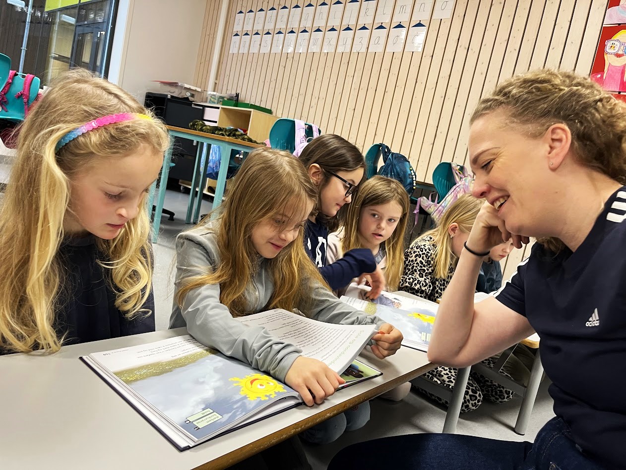 Lærer og elever leser i klasserommet