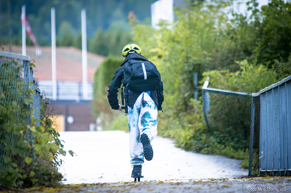 Gutt på skoleveien. Sett bakfra på sparkesykkel