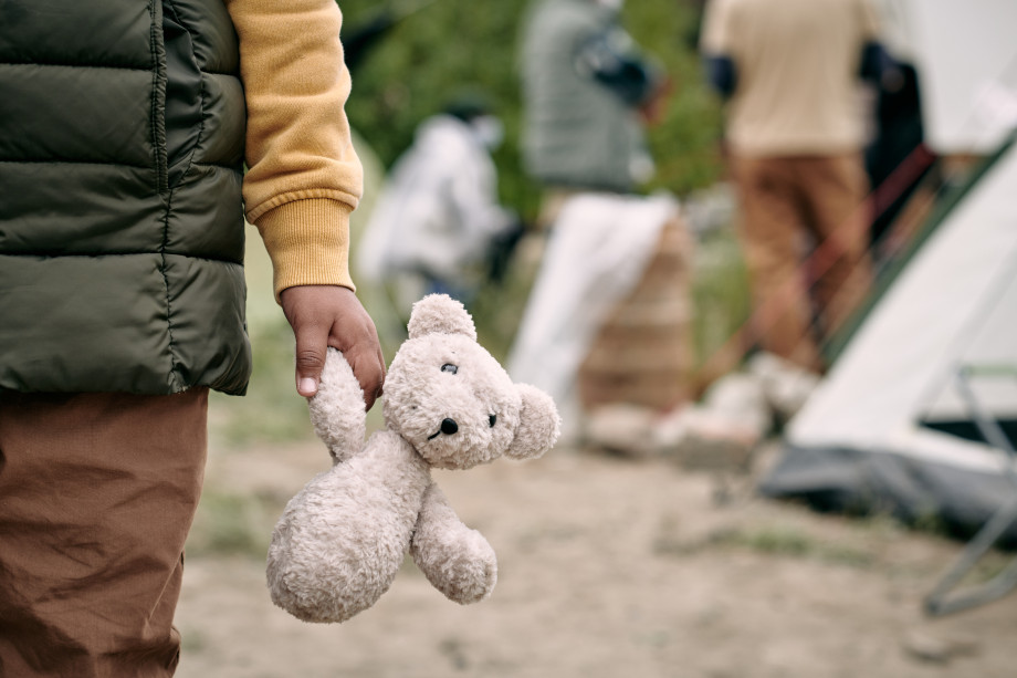 Barn i flyktningleir. Holder en ødelagt bamse.