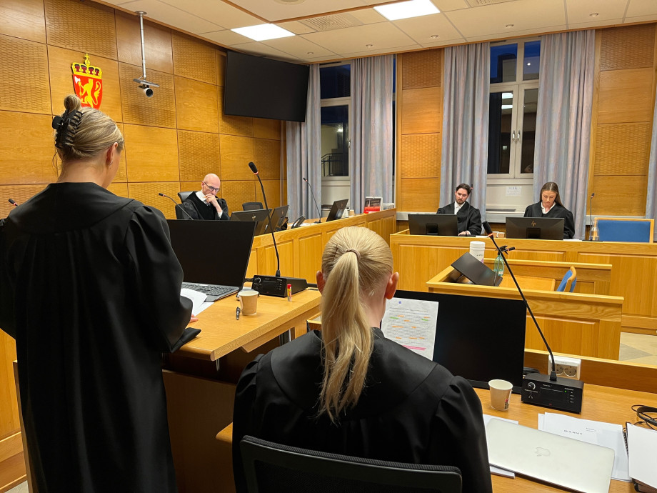 Studenter sammen med advokat i rettssalen.