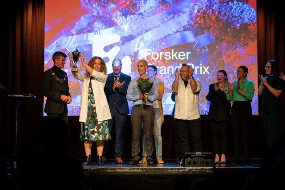 Flere folk på scenen. En holder en pokal.