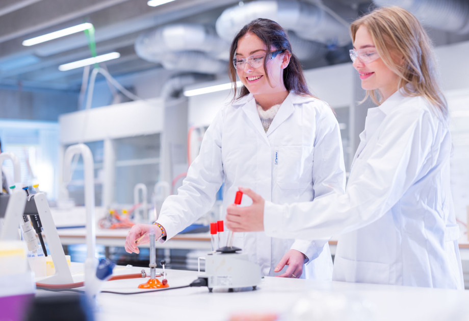 To personer med labfrakk jobber på et laboratorium. Foto